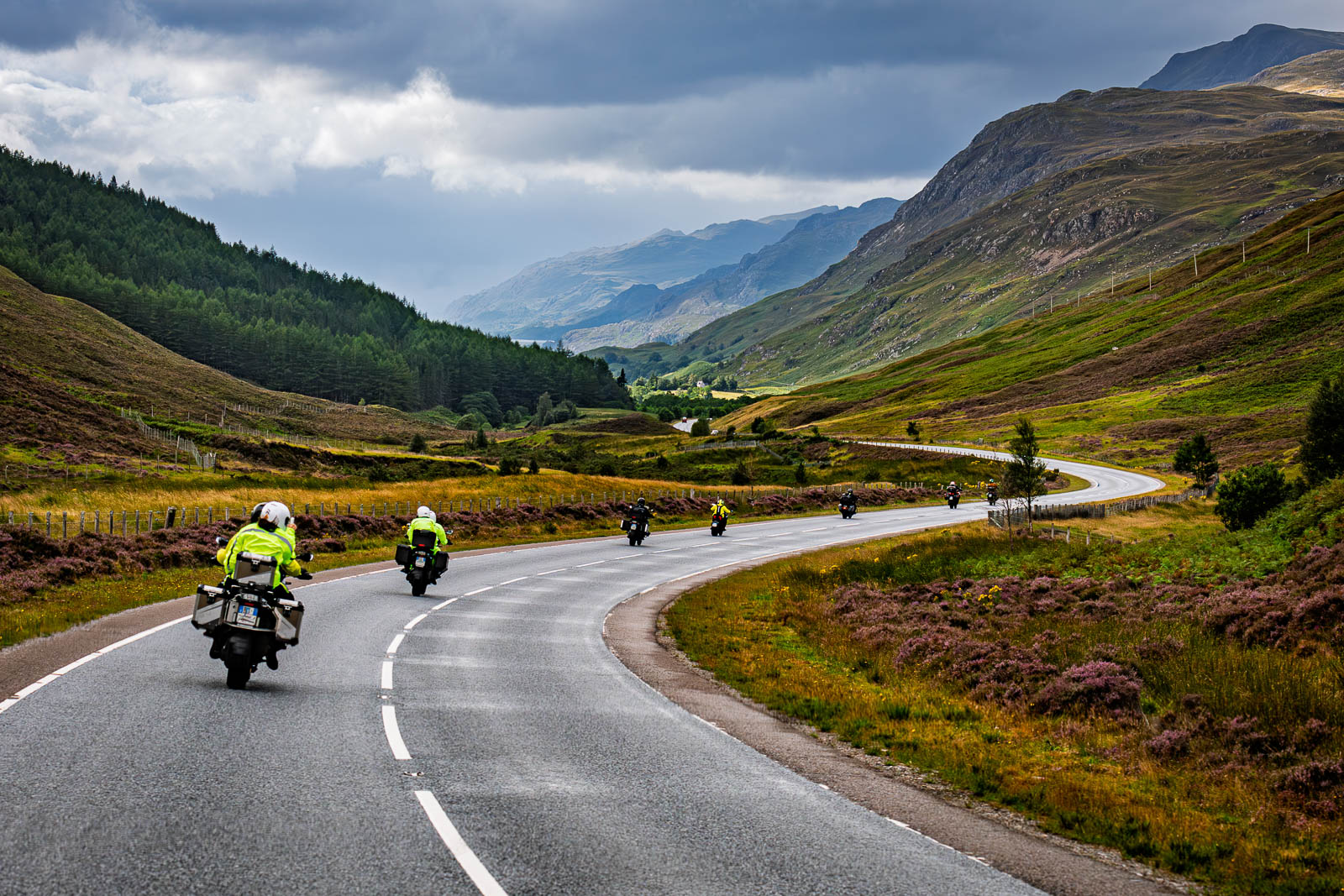 Gruppo di motociclisti in viaggio tra le montagne delle Highlands in Scozia, che percorrono una strada panoramica durante un viaggio di Libermoto